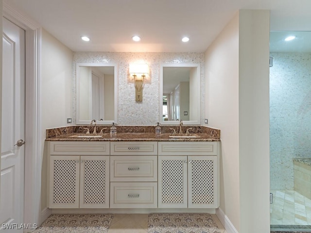 bathroom featuring double vanity, a sink, and a shower stall