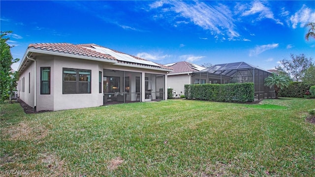 rear view of property with a yard, a lanai, and a sunroom