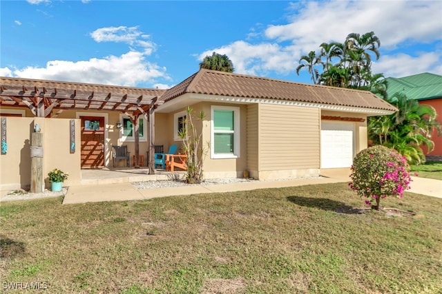 rear view of house with a garage, a pergola, a patio area, and a lawn