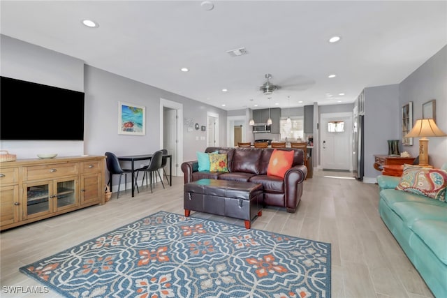 living room with ceiling fan and light wood-type flooring