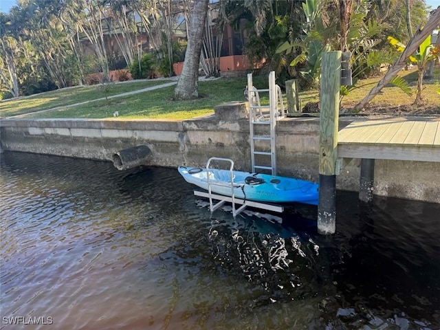 view of dock featuring a water view and a lawn