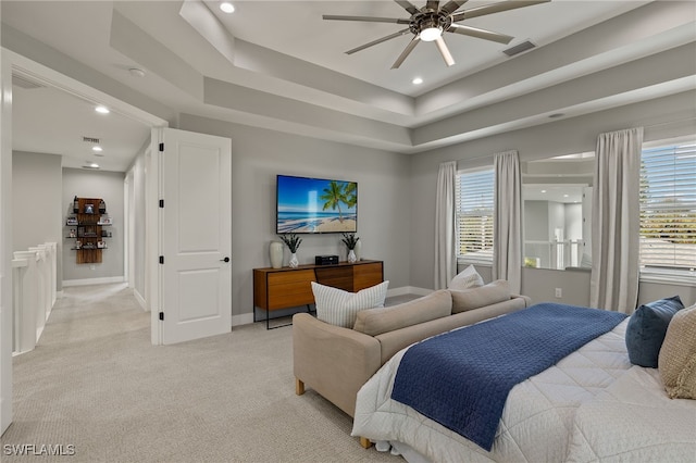 carpeted bedroom with a raised ceiling