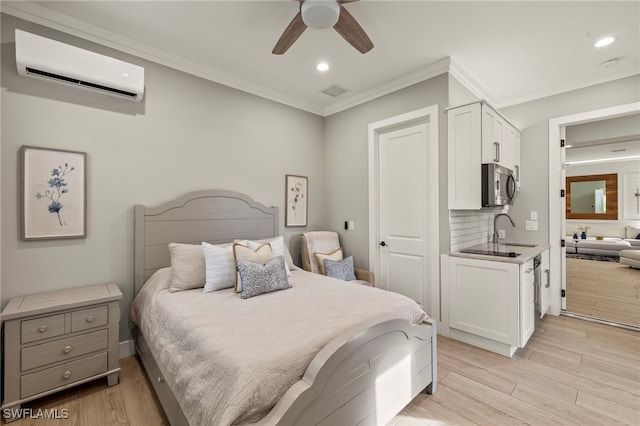 bedroom featuring sink, ornamental molding, light hardwood / wood-style floors, and a wall mounted AC