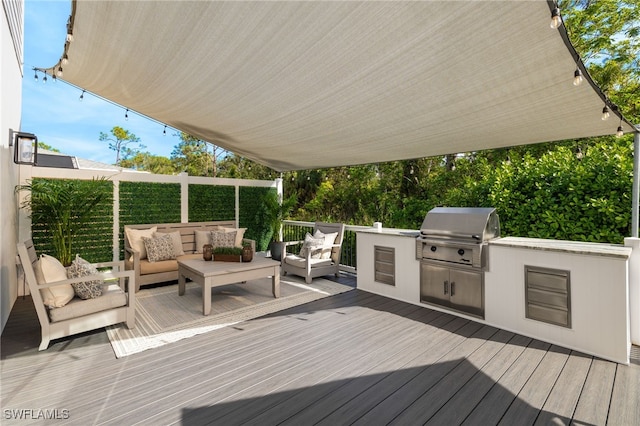 deck with a grill, exterior kitchen, and an outdoor living space