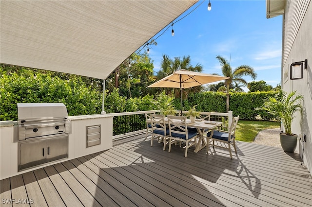 wooden terrace with grilling area and an outdoor kitchen