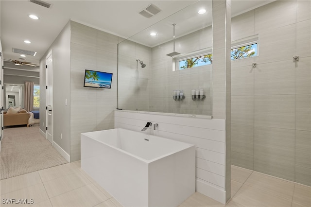 bathroom with tile walls, a wealth of natural light, and shower with separate bathtub