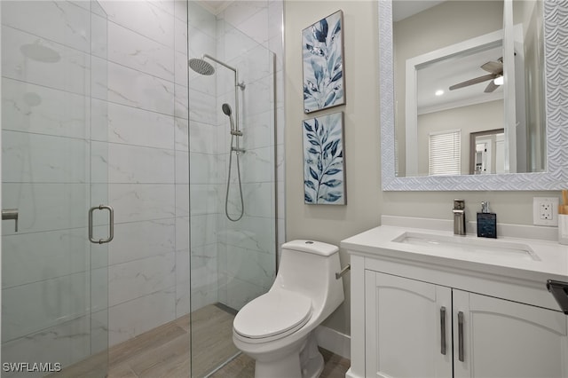 bathroom featuring vanity, a shower with shower door, ceiling fan, and toilet