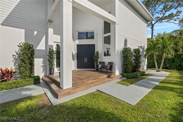 doorway to property featuring a lawn