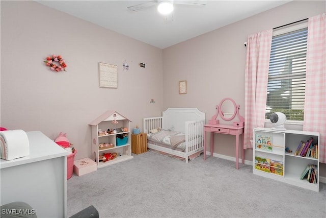 carpeted bedroom with a nursery area and ceiling fan