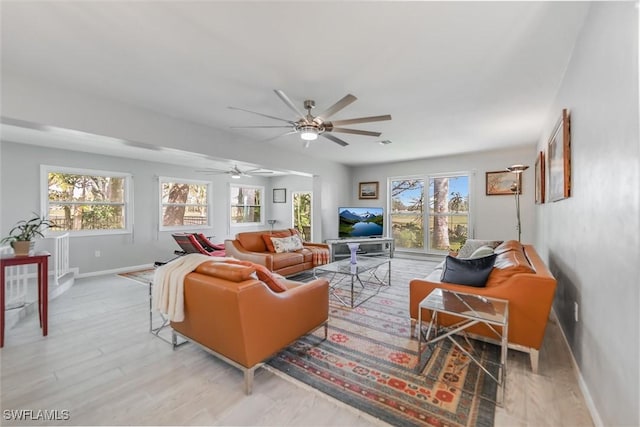 living room with ceiling fan and light hardwood / wood-style floors