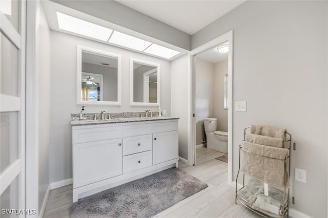 bathroom featuring vanity, toilet, and hardwood / wood-style floors