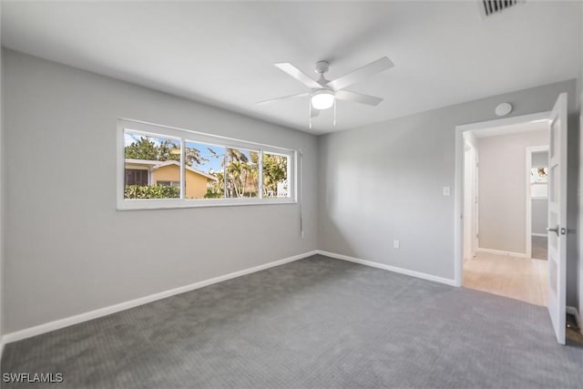 unfurnished room featuring ceiling fan and dark colored carpet