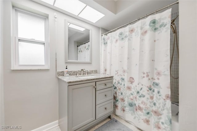 bathroom featuring vanity, shower / bath combo, and a skylight