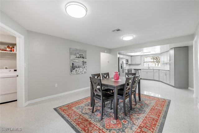 dining room with washer / dryer and sink