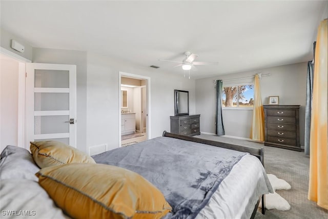 carpeted bedroom featuring ceiling fan and ensuite bath