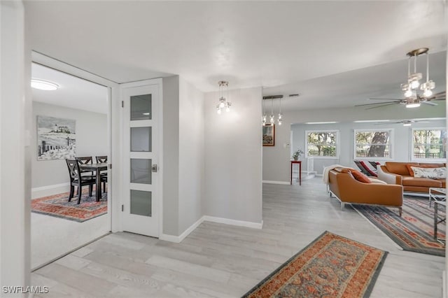 hall featuring plenty of natural light and light hardwood / wood-style floors