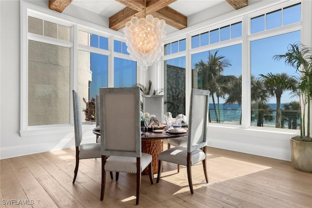 sunroom / solarium featuring beamed ceiling, a water view, coffered ceiling, and a notable chandelier