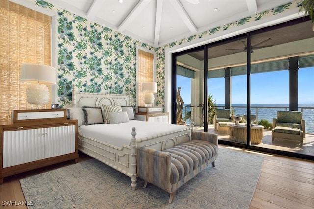 bedroom featuring a water view, beamed ceiling, and hardwood / wood-style flooring