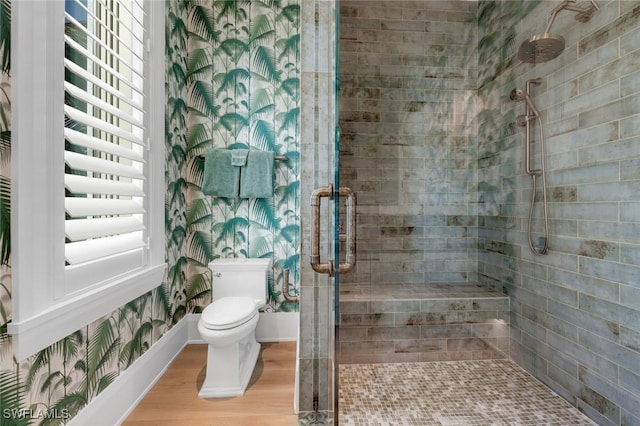bathroom featuring toilet, a shower with shower door, and hardwood / wood-style floors