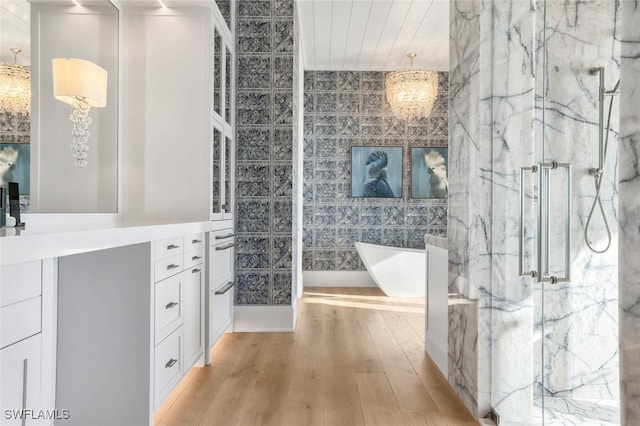bathroom with a chandelier, vanity, separate shower and tub, and hardwood / wood-style flooring