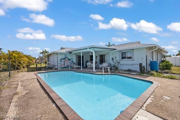 back of house featuring a fenced in pool and a patio