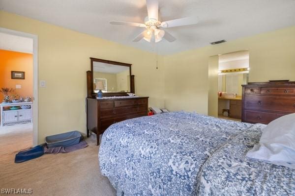 carpeted bedroom featuring ensuite bathroom and ceiling fan