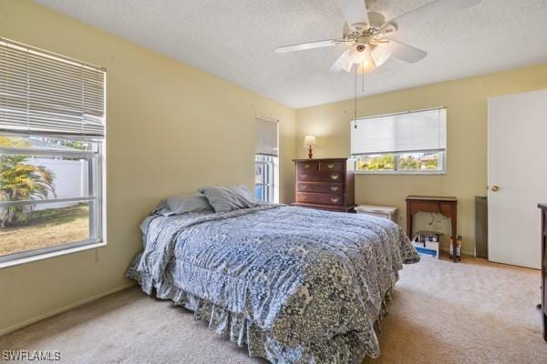 bedroom with light carpet, a textured ceiling, and ceiling fan