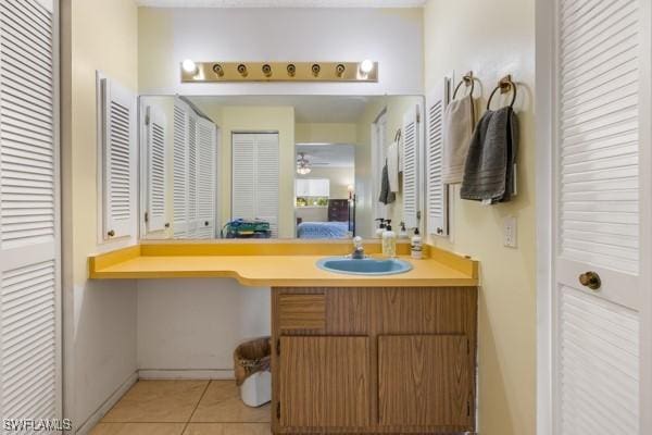 bathroom with connected bathroom, vanity, and tile patterned floors