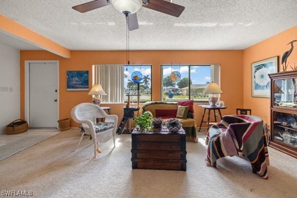 living room featuring ceiling fan and a textured ceiling