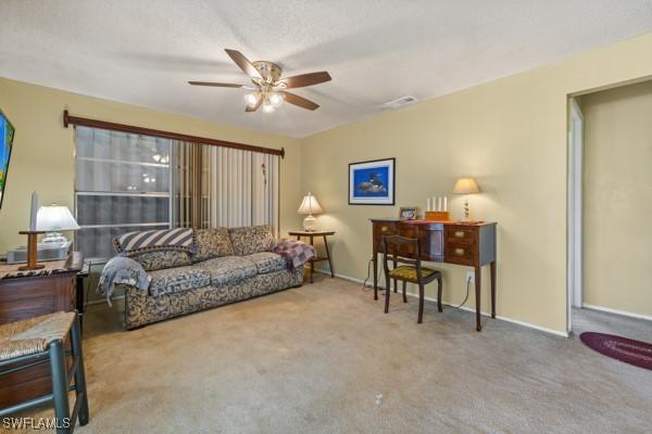 living room featuring ceiling fan and carpet