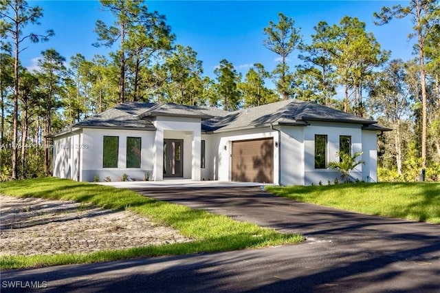 4091 56th Ave NE, Naples, FL 34120 - prairie-style house with stucco siding, an attached garage, driveway, and a front yard