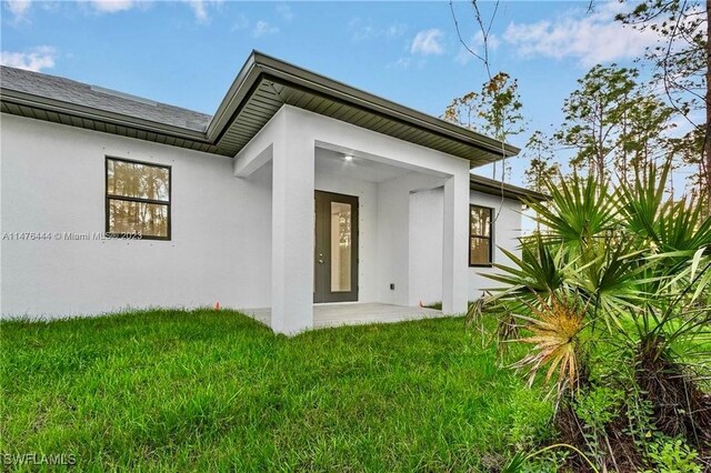 4091 56th Ave NE, Naples, FL 34120 - property entrance featuring a lawn and stucco siding
