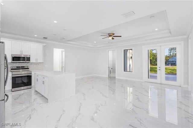 4091 56th Ave NE, Naples, FL 34120 - kitchen with appliances with stainless steel finishes, a tray ceiling, open floor plan, a center island, and ornamental molding