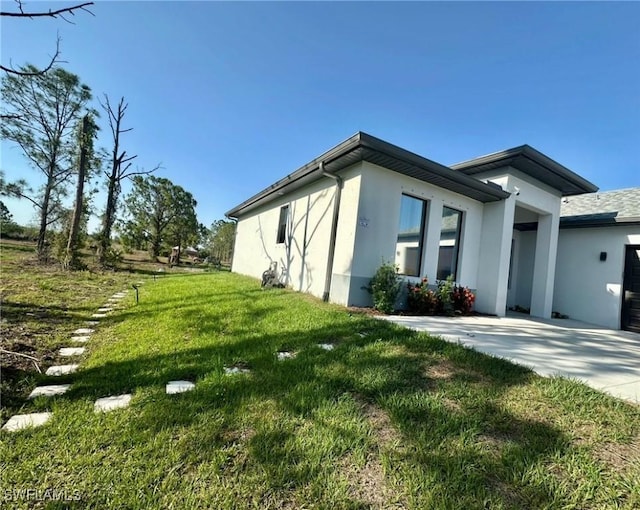 4091 56th Ave NE, Naples, FL 34120 - view of property exterior featuring stucco siding and a lawn