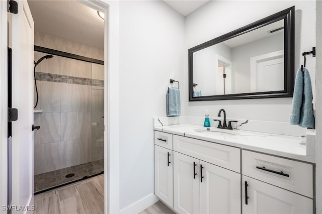 bathroom featuring tiled shower and vanity