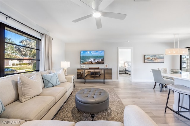 living room with ceiling fan and light wood-type flooring