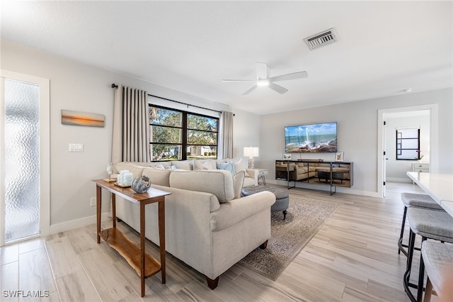 living room featuring ceiling fan and light hardwood / wood-style flooring