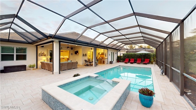 view of pool with a patio area, glass enclosure, a pool with connected hot tub, and outdoor lounge area