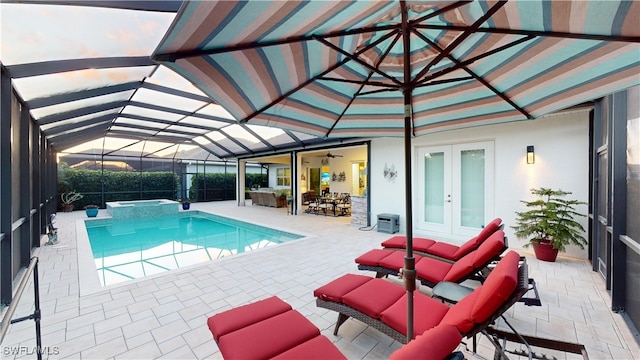 view of pool with a patio area, glass enclosure, french doors, and a pool with connected hot tub