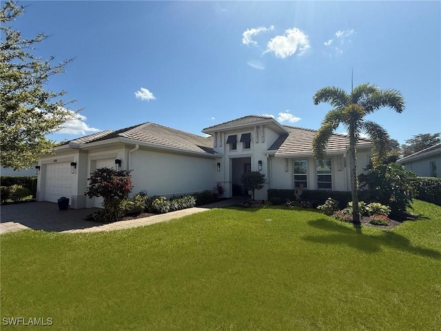 view of front of home featuring a garage, stucco siding, a front yard, and a tiled roof