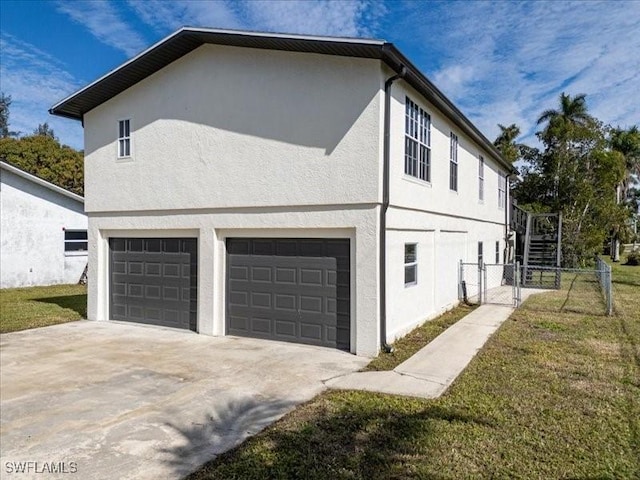 view of side of home featuring a garage and a lawn