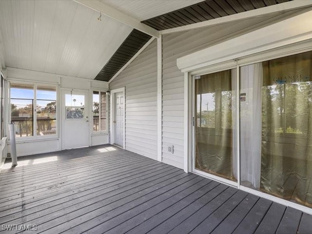 unfurnished sunroom featuring vaulted ceiling