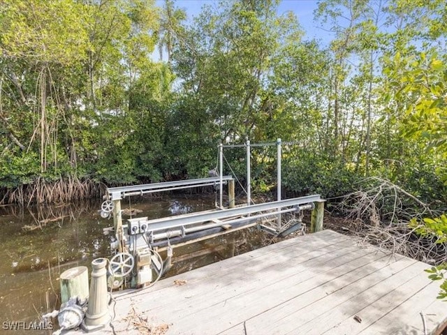 wooden terrace featuring a water view and a dock