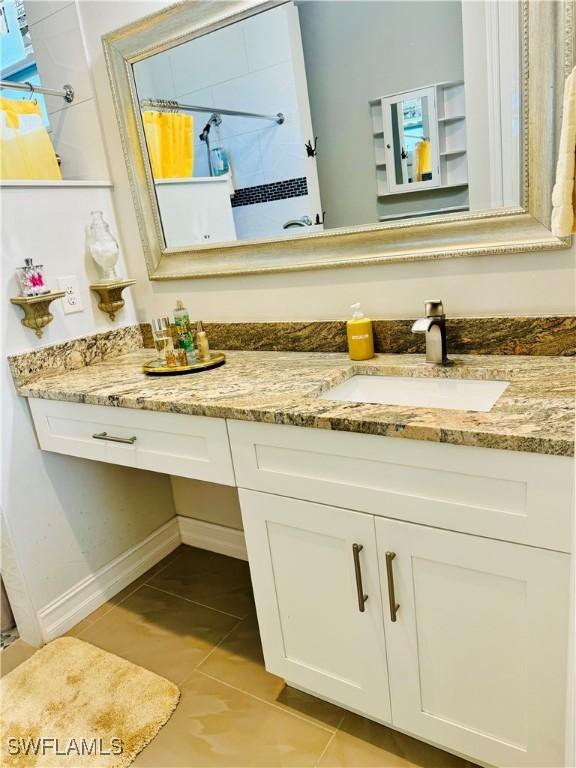 bathroom with tile patterned flooring, vanity, and curtained shower