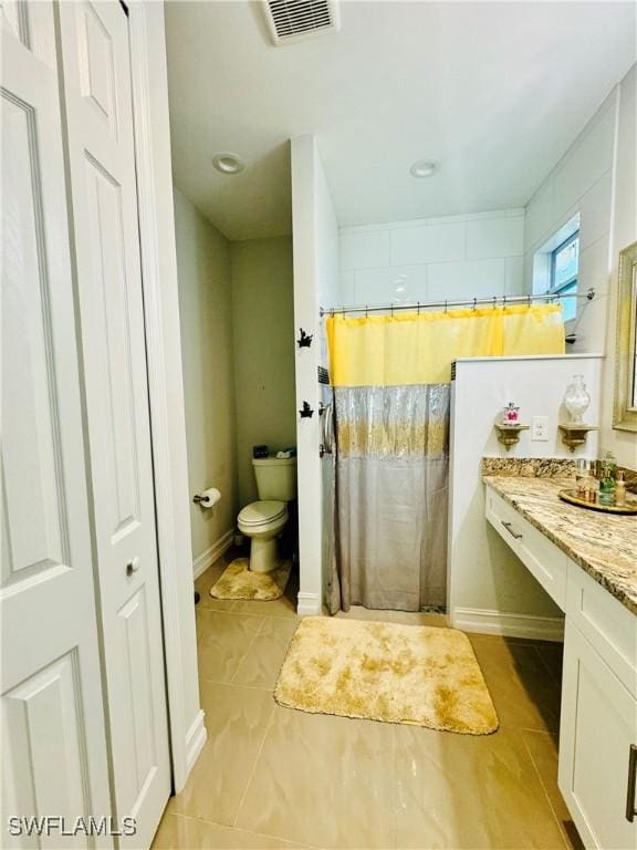 bathroom with vanity, a shower with curtain, tile patterned floors, and toilet