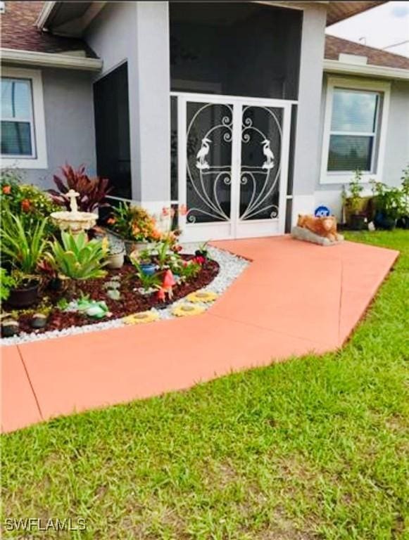 view of exterior entry with a lawn