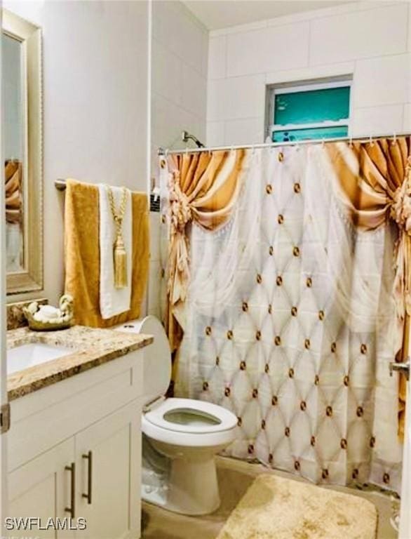 bathroom featuring vanity, toilet, and curtained shower