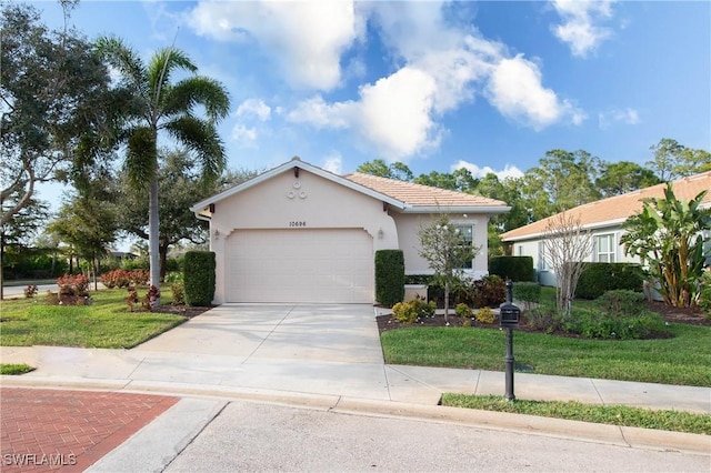 10696 Camarelle Cir, Fort Myers, FL 33913 - view of front of property with stucco siding, concrete driveway, a garage, and a front yard
