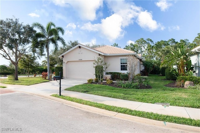 10696 Camarelle Cir, Fort Myers, FL 33913 - view of front of home featuring a garage, driveway, stucco siding, and a front yard