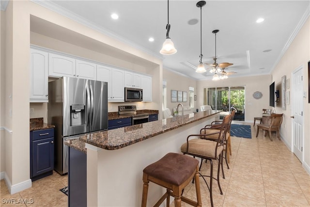 10696 Camarelle Cir, Fort Myers, FL 33913 - kitchen with stainless steel appliances, a kitchen breakfast bar, white cabinets, crown molding, and light tile patterned flooring